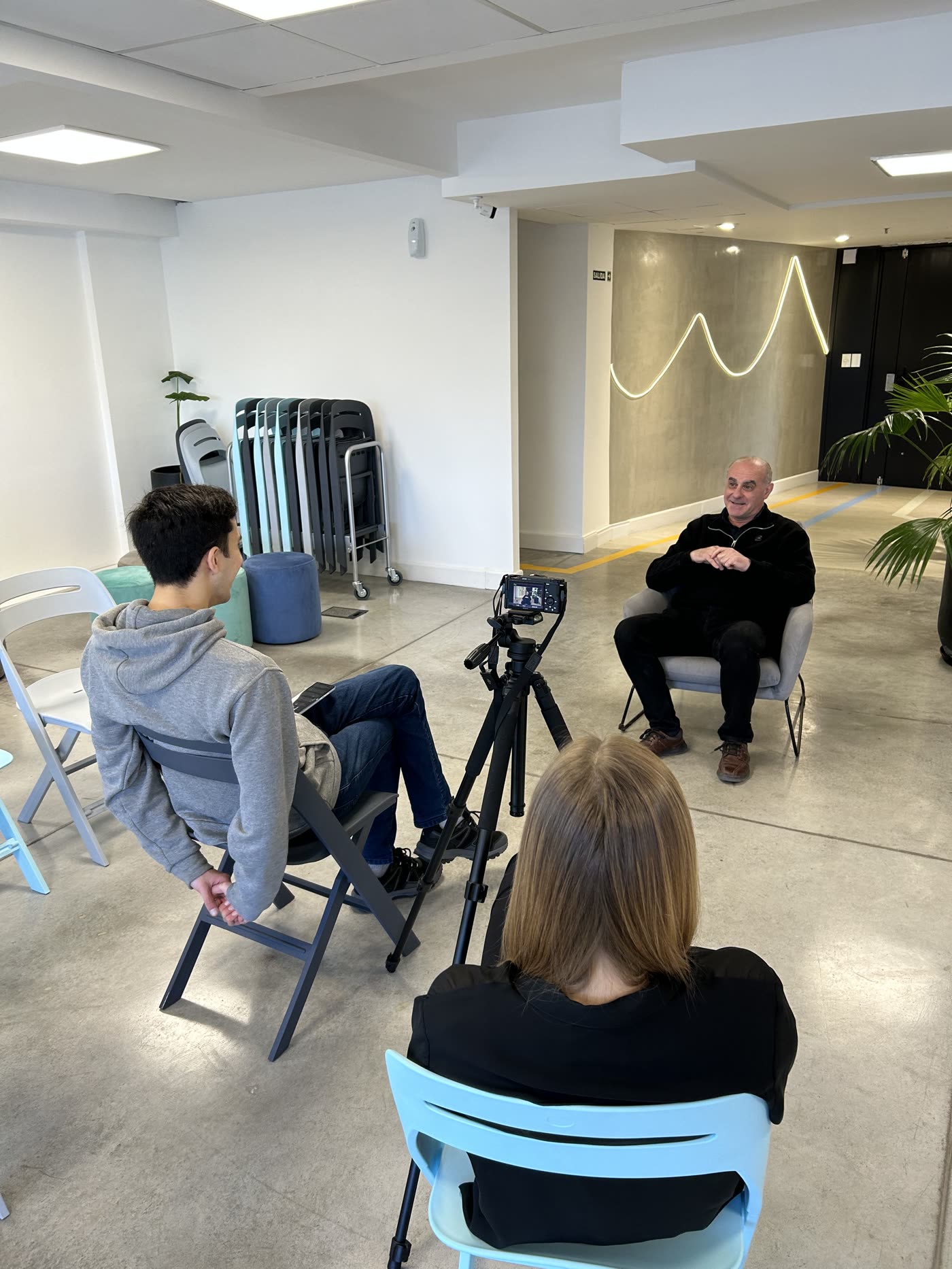 Equipo de Cinco grabando una entrevista con cámara en trípode